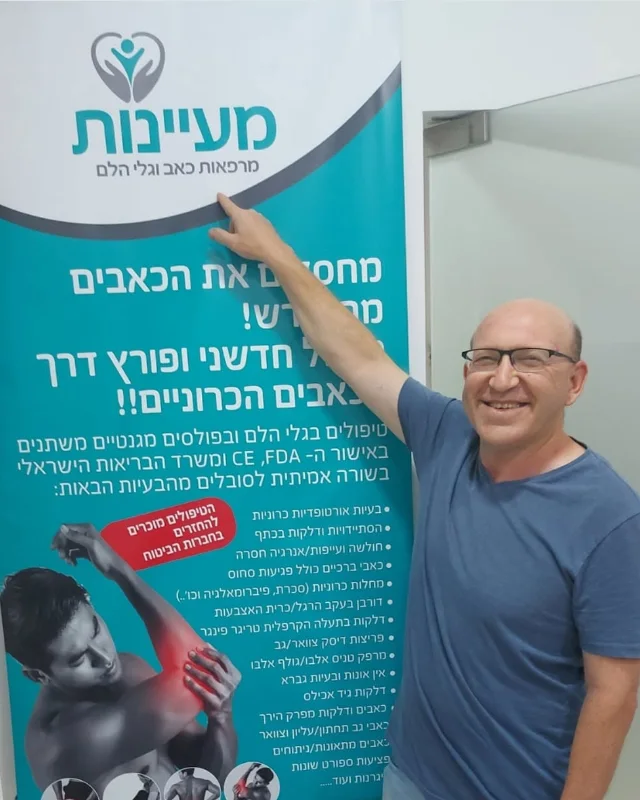 מטופל מרוצה מצביע על שלט מעיינות בקליניקה