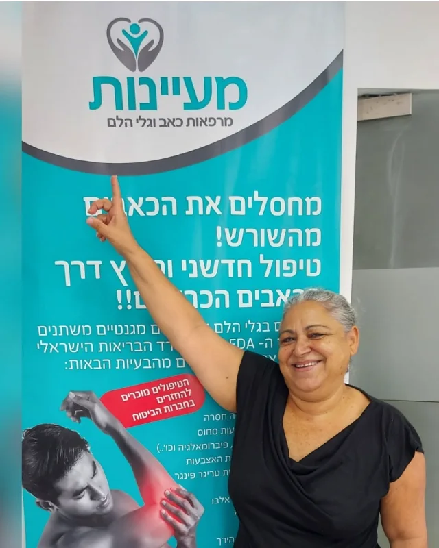 מטופל מרוצה מצביע על שלט מעיינות בקליניקה