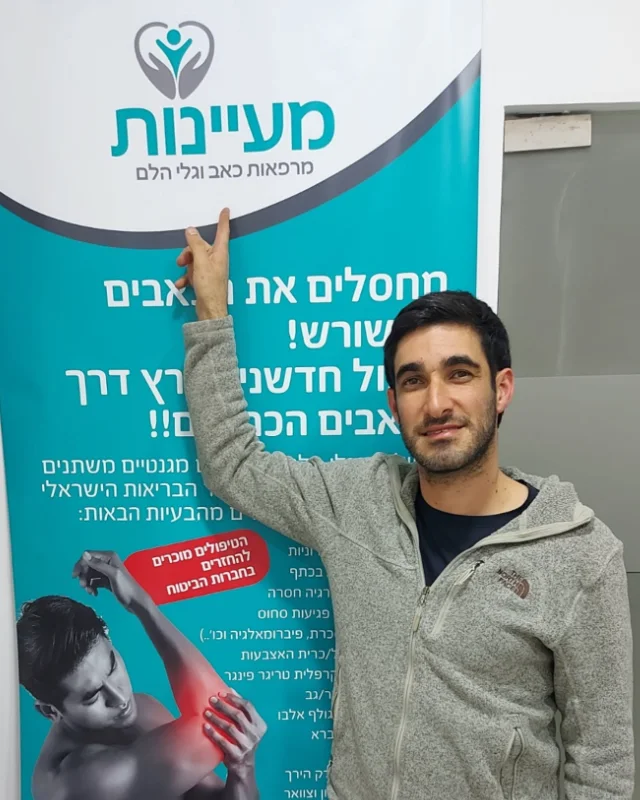 מטופל מרוצה מצביע על שלט מעיינות בקליניקה
