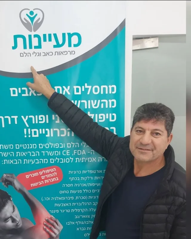 מטופל מרוצה מצביע על שלט מעיינות בקליניקה