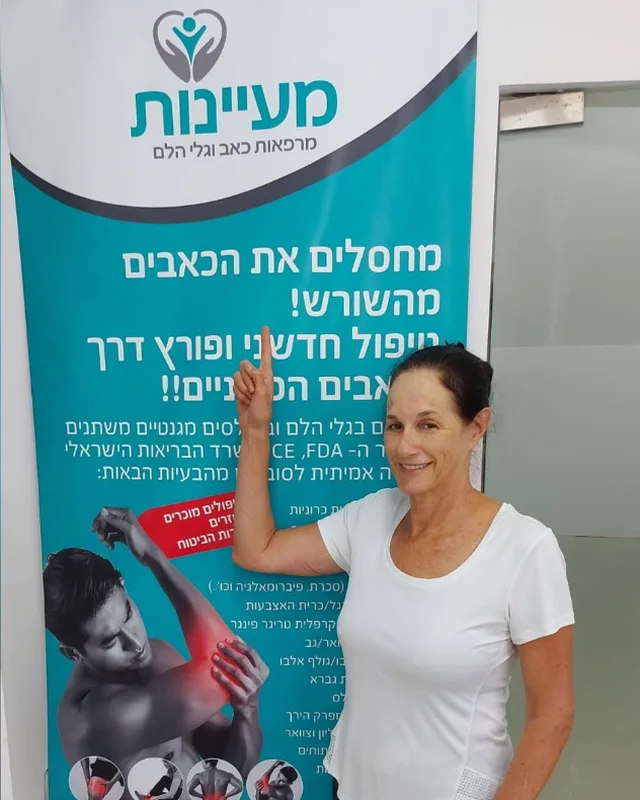 מטופל מרוצה מצביע על שלט מעיינות בקליניקה