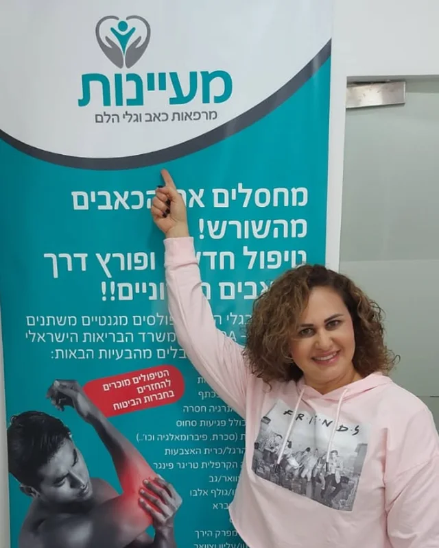 מטופל מרוצה מצביע על שלט מעיינות בקליניקה