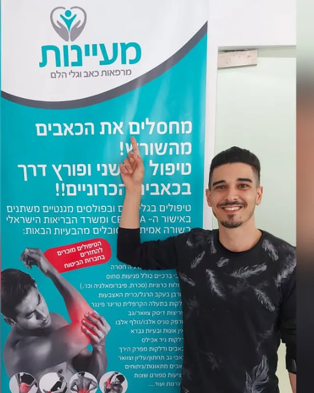 מטופל מרוצה מצביע על שלט מעיינות בקליניקה