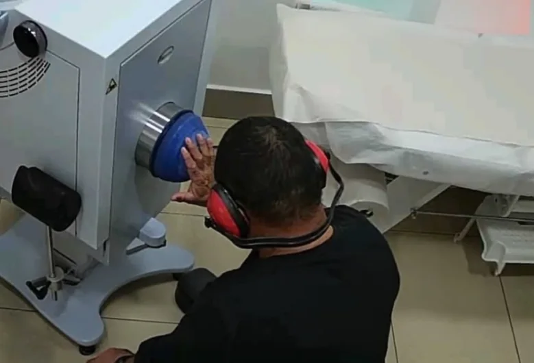 מטופל בטיפול גלי הלם בכף היד במכשיר נייח בקליניקת מעיינות